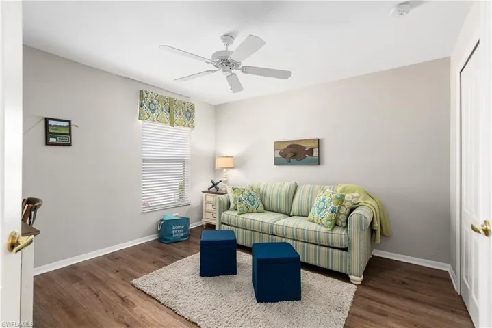 Living room featuring wood finished floors, baseboards, and ceiling fan