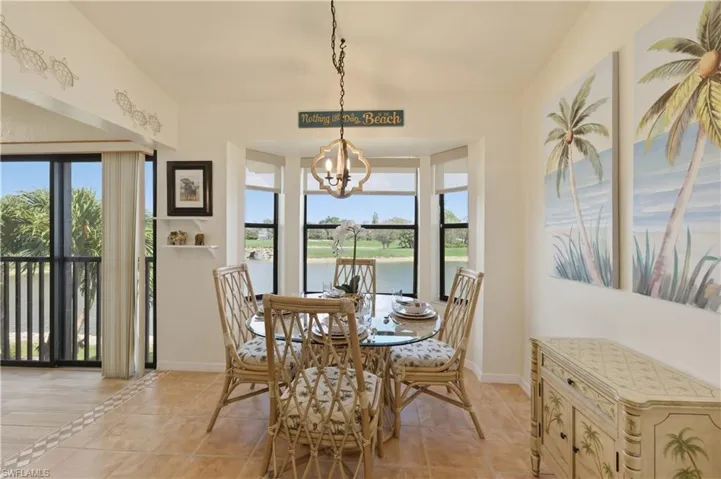 Dining space featuring light tile patterned floors, a chandelier, and a water view