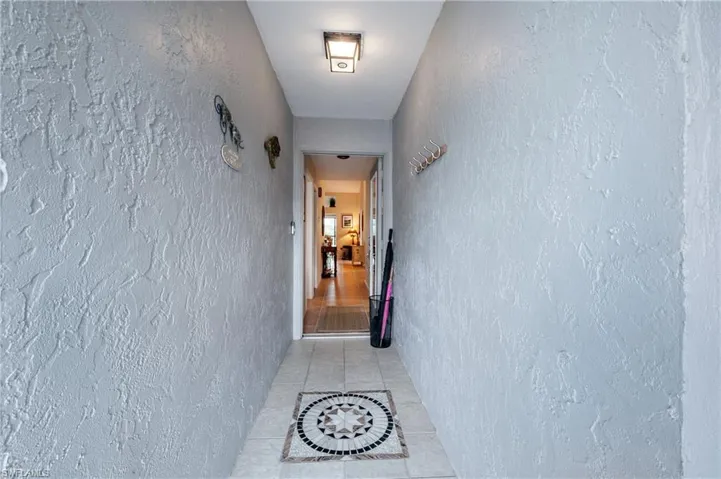 Hallway featuring light tile patterned flooring