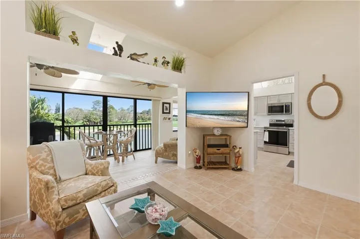 Living area with vaulted ceiling and light tile patterned flooring
