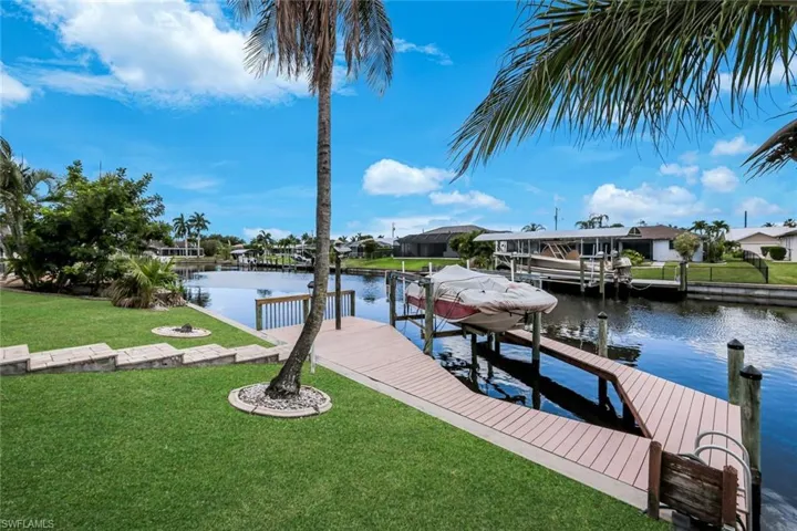 Waterfront property featuring a composite dock, boat lift, and canal access