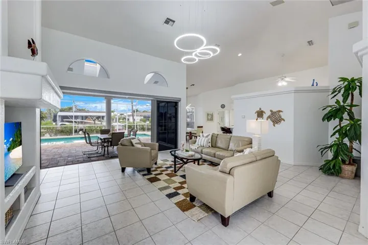 Spacious living area featuring high vaulted ceilings and light tile flooring