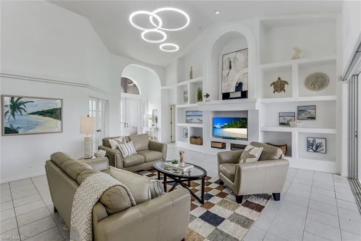 Spacious living area featuring a vaulted ceiling and tile flooring