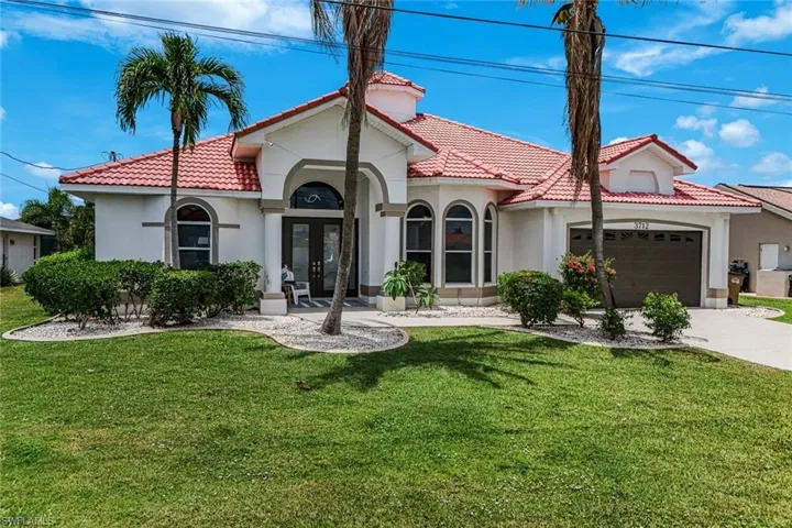 Mediterranean-style residence featuring a red tile roof and arched entryways
