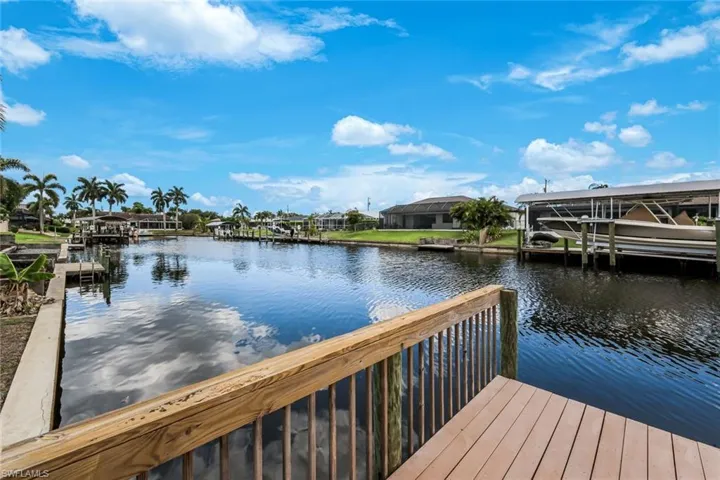 Waterfront canal with a private wooden dock and railing