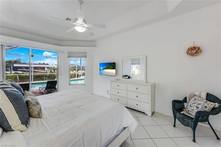 Spacious room featuring tile flooring, a vaulted ceiling, and a ceiling fan with integrated lighting