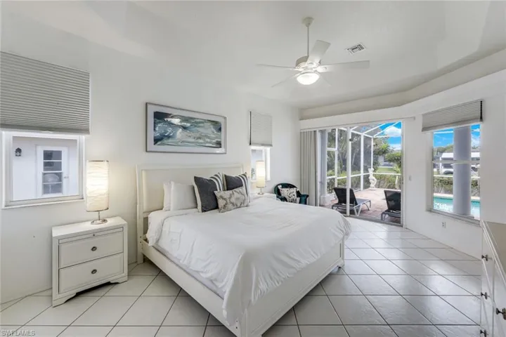 Spacious room featuring large format tile flooring, a ceiling fan with integrated lighting, and multiple windows with horizontal blinds