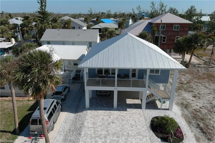 Back of property featuring a residential view, stairway, a metal roof, and covered porch