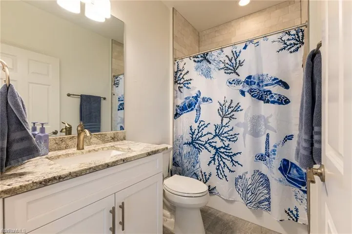 Full bath with vanity, shower / tub combo with curtain, and recessed lighting