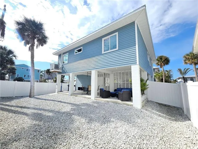 Back of house featuring a fenced backyard, a patio area, a carport, and an outdoor hangout area