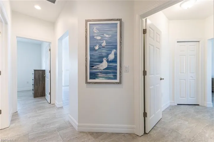 Hall with baseboards and recessed lighting