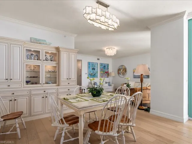 Dining room featuring crown molding, a chandelier, and light hardwood / wood-style flooring
