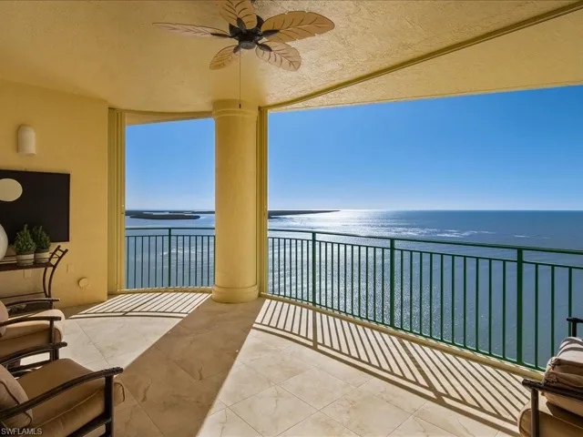 Balcony with a water view and ceiling fan