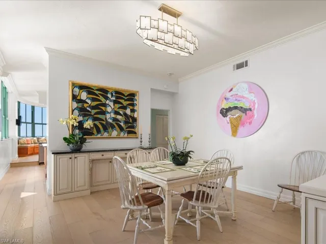 Dining room featuring ornamental molding, a chandelier, and light hardwood / wood-style flooring