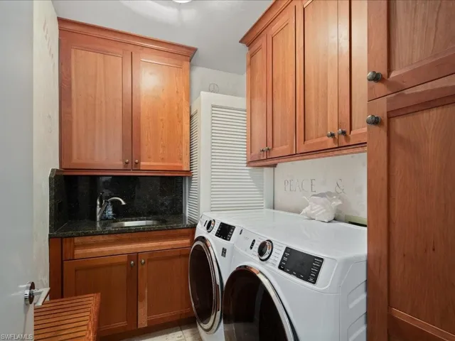 Laundry room featuring cabinets, sink, and washer and dryer