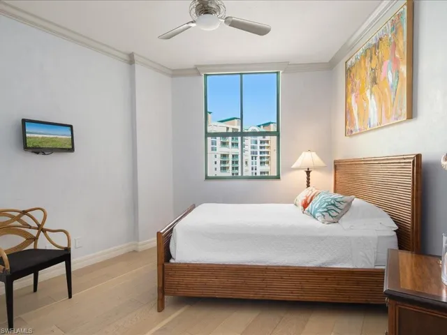 Bedroom with ceiling fan, ornamental molding, and light hardwood / wood-style flooring