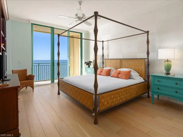 Bedroom featuring ornamental molding, access to exterior, light hardwood / wood-style floors, floor to ceiling windows, and a water view