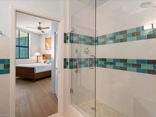 Bathroom with wood-type flooring, ceiling fan, and walk in shower