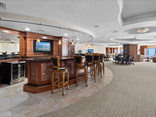 Bar featuring beverage cooler and decorative light fixtures