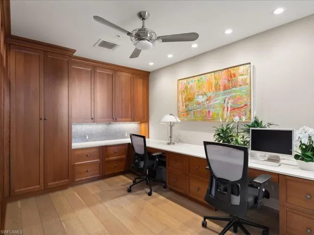 Office featuring ceiling fan, built in desk, and light hardwood / wood-style floors