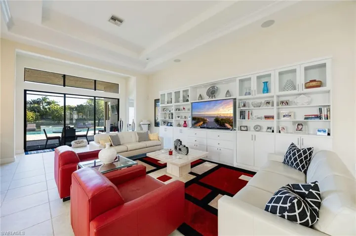 Living area featuring a high ceiling, light tile patterned floors, and a raised ceiling