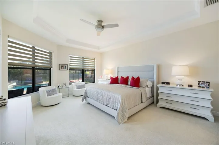 Bedroom featuring a tray ceiling, carpet, ceiling fan, and ornamental molding