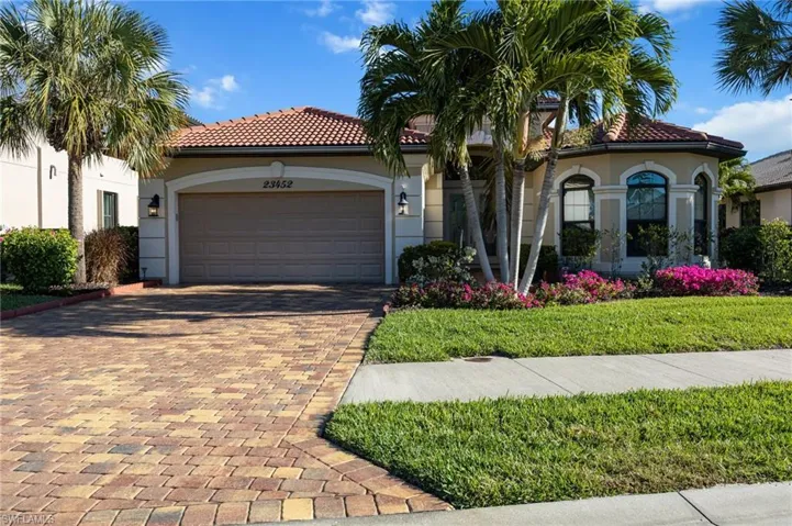 Mediterranean / spanish-style house featuring decorative driveway, an attached garage, stucco siding, and a tiled roof