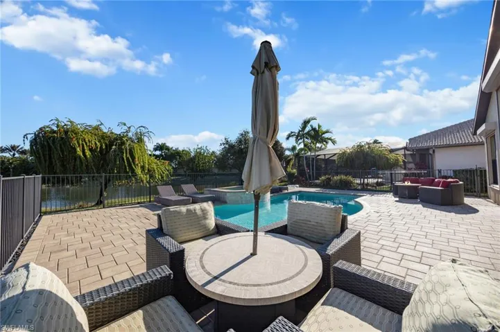 Fenced backyard featuring a patio, outdoor lounge area, outdoor dining area, and a pool with connected hot tub