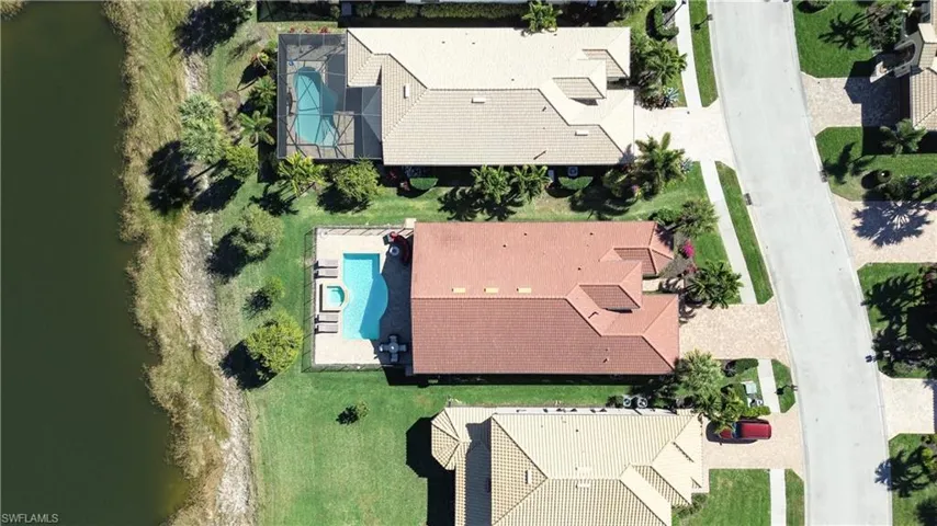 Drone / aerial view of a pool area and a large body of water