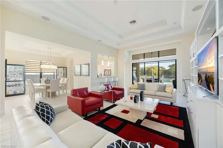 Living area with a tray ceiling and plenty of natural light
