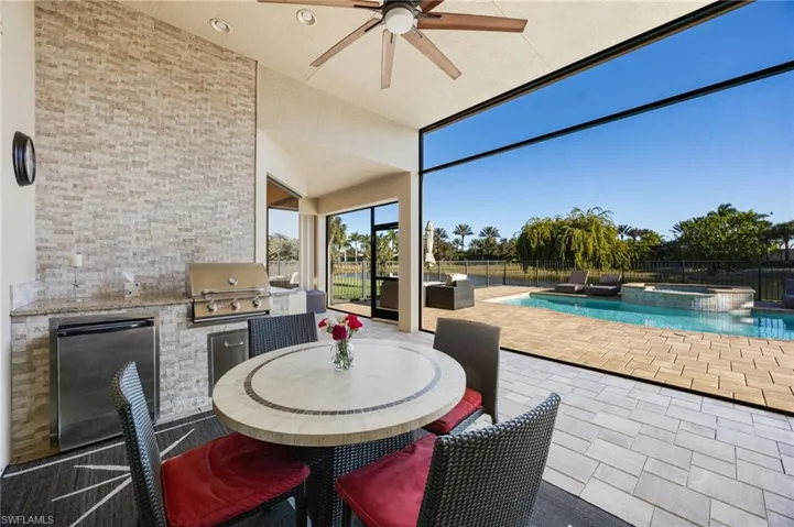 Fenced backyard with area for grilling, outdoor dining area, a patio, a ceiling fan, and a pool with connected hot tub