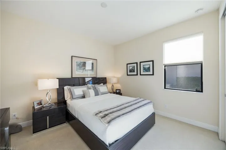 Bedroom with baseboards and light colored carpet