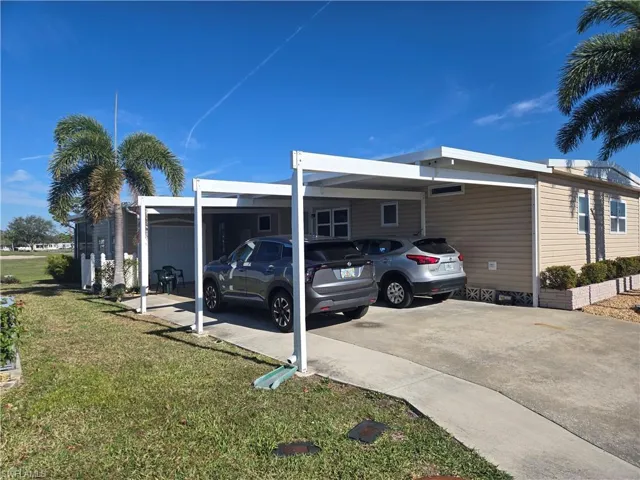 View of side of home with a yard and a carport