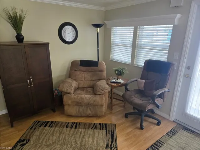 Sitting room with ornamental molding, a wealth of natural light, and light hardwood / wood-style floors