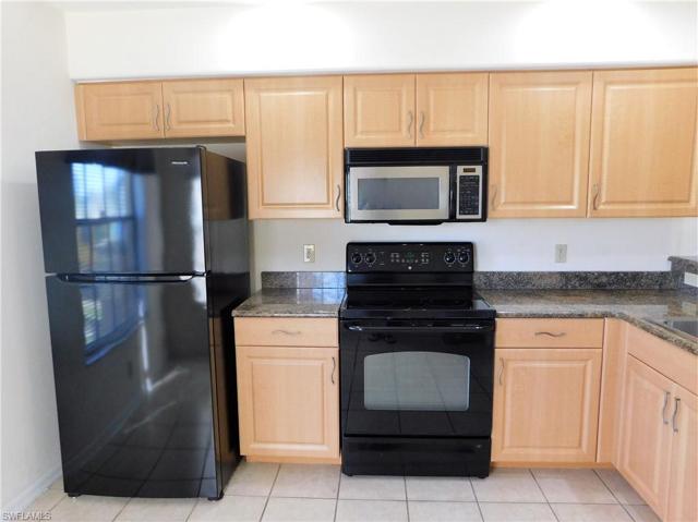 Kitchen features beveled wood cabinetry and granite countertops.