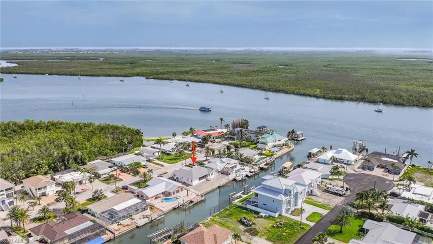 Aerial view of property and surrounding area with a nearby body of water and nearby suburban area