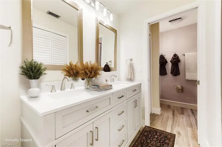 Bathroom with double vanity and wood finished floors