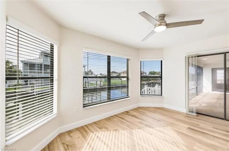 Unfurnished room with wood finished floors, plenty of natural light, and a ceiling fan