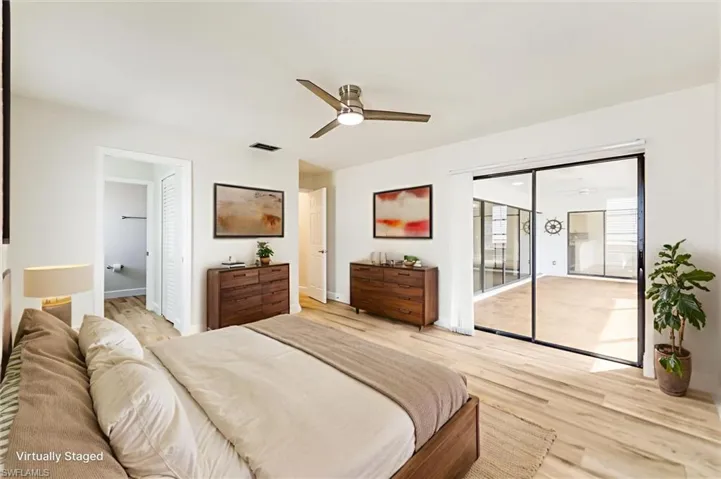 Bedroom featuring access to outside, light wood finished floors, and a ceiling fan