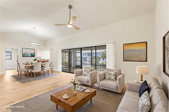 Living area featuring lofted ceiling, light wood-style floors, and ceiling fan