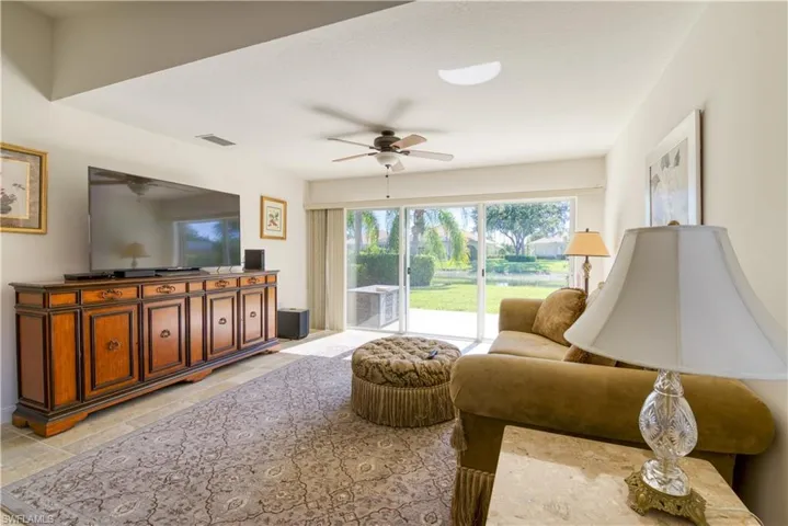 Spacious living area featuring tile flooring, a built-in media console, and a ceiling fan