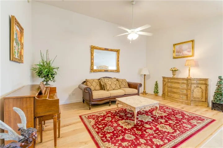 Spacious room featuring vaulted ceilings, wood-finish flooring, and a ceiling fan with light fixture