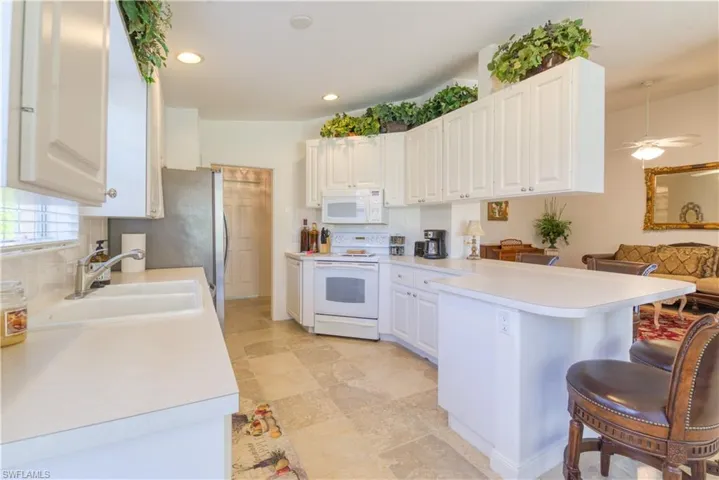 Kitchen featuring white cabinetry, light-toned countertops, and stone-finish tile flooring