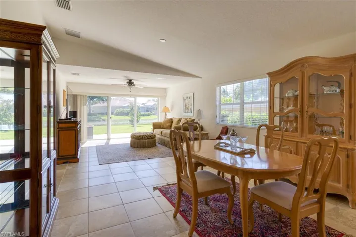 Open-concept living area with tile flooring and a vaulted ceiling