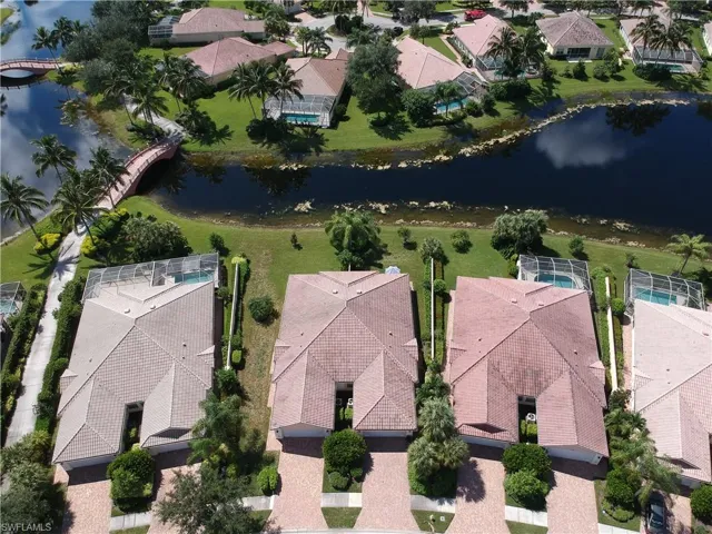 Aerial perspective showcasing multiple properties, each featuring a tile roof and a private swimming pool with a screen enclosure