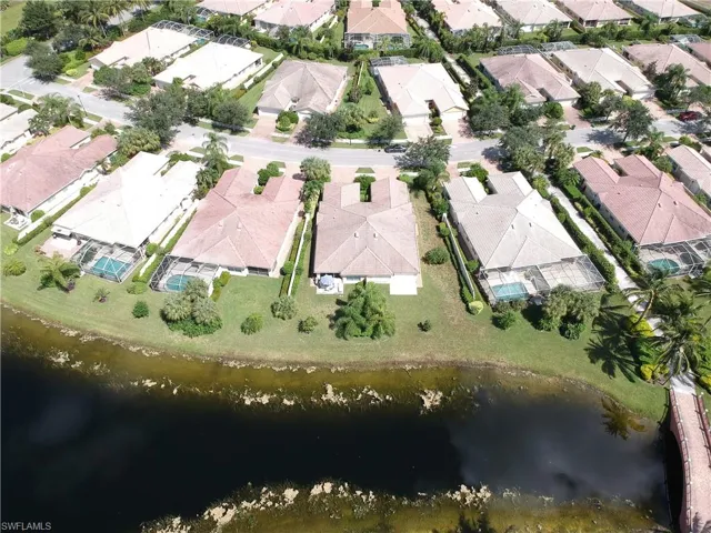 Lakeside residential community featuring single-story homes with tile roofs, private screened pools, and mature landscaping