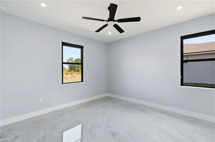 Unfurnished room with a ceiling fan, recessed lighting, and light marble finish floors
