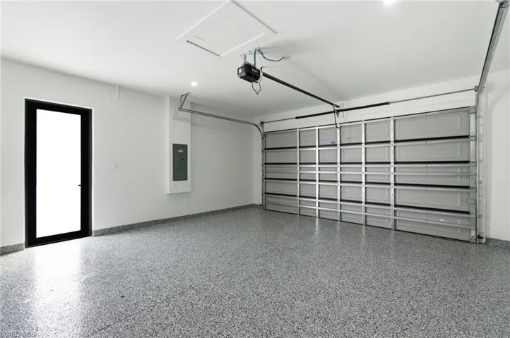 Garage featuring electric panel and a garage door opener