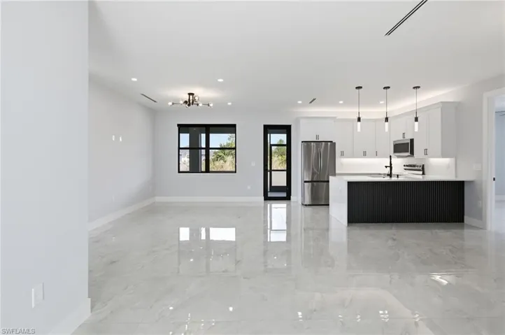 Unfurnished living room with light marble finish flooring and recessed lighting