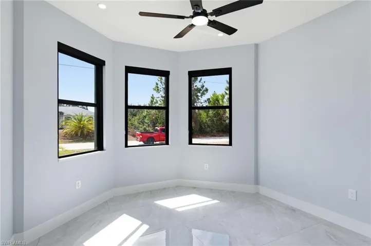 Spare room with a ceiling fan, light marble finish floors, and recessed lighting